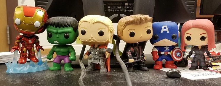 Funko Pop Avengers on desk guarding office.